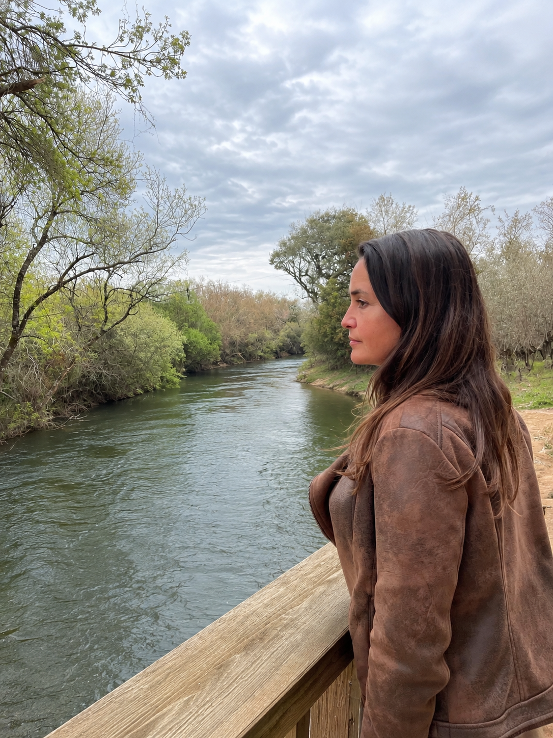 Daniela Velho de perfil, junto ao rio, a olhar a paisagem